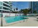 Inviting outdoor pool with plenty of lounge chairs, palm trees, and ocean views at 988 Blvd Of The Arts # 1016, Sarasota, FL 34236