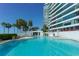 Inviting outdoor pool with plenty of lounge chairs, palm trees, and ocean views at 988 Blvd Of The Arts # 1016, Sarasota, FL 34236