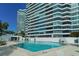 Inviting outdoor pool with plenty of lounge chairs, palm trees, and ocean views at 988 Blvd Of The Arts # 1016, Sarasota, FL 34236