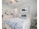 Bright bedroom featuring wood-look floors, ceiling fan, and coastal-themed decor at 10423 Morning Marsh Ln, Parrish, FL 34219