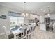 Dining area with white table and chairs, blue accents, view into kitchen at 10423 Morning Marsh Ln, Parrish, FL 34219