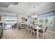 Dining area featuring a white dining set, adjacent to the living room and view to pool at 10423 Morning Marsh Ln, Parrish, FL 34219