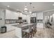Bright modern kitchen with white cabinets, stainless steel appliances, granite countertops, island with bar seating at 10423 Morning Marsh Ln, Parrish, FL 34219