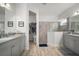 Main bathroom featuring double sinks, walk-in shower, and seamless entry to the walk-in closet at 10423 Morning Marsh Ln, Parrish, FL 34219