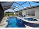 Beautiful pool and spa with waterfall feature in screened-in lanai; perfect for outdoor relaxation and entertaining at 10423 Morning Marsh Ln, Parrish, FL 34219