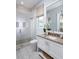 Bright bathroom with a glass shower, white vanity, neutral countertop, and a window with natural light at 1198 Blue Shell Loop, Sarasota, FL 34240