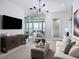 Bright living room featuring modern lighting, a large TV, comfortable seating, and a view of the outdoor patio and lake at 1198 Blue Shell Loop, Sarasota, FL 34240