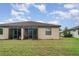 Exterior of home featuring a screen enclosed porch and view of the grassy backyard at 12515 Garibaldi Ln, Venice, FL 34293