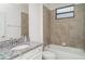 Well-lit bathroom featuring granite countertops, neutral tiling, and a shower-tub combo at 12515 Garibaldi Ln, Venice, FL 34293