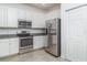 Modern kitchen featuring stainless steel appliances, granite countertops, tile flooring, and white cabinets at 12515 Garibaldi Ln, Venice, FL 34293
