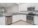 Modern kitchen with stainless steel appliances, white cabinetry, granite counters, and tile flooring at 12515 Garibaldi Ln, Venice, FL 34293