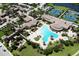 Aerial view of a large community pool with ample seating, surrounded by palm trees and lush landscaping at 12515 Garibaldi Ln, Venice, FL 34293