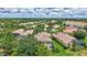 A high-angle aerial view showcasing a neighborhood with lush landscaping, and a winding lake in the distance at 12710 Stone Ridge Pl, Lakewood Ranch, FL 34202