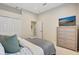 Bright bedroom featuring neutral walls, soft carpet, and a modern TV on a dresser at 12710 Stone Ridge Pl, Lakewood Ranch, FL 34202