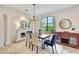 Bright dining room with modern chandelier, fireplace, and large windows overlooking verdant greenery at 12710 Stone Ridge Pl, Lakewood Ranch, FL 34202