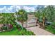 Aerial view of a well-maintained home showcasing lush landscaping, a brick driveway, and a two-car garage at 12710 Stone Ridge Pl, Lakewood Ranch, FL 34202