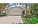 Charming single-story home featuring a three-car garage and beautifully landscaped front yard with mature trees at 12710 Stone Ridge Pl, Lakewood Ranch, FL 34202