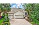 Well-manicured front yard and driveway leading to the attached three-car garage of a single-story home at 12710 Stone Ridge Pl, Lakewood Ranch, FL 34202