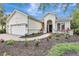 Beautifully landscaped front yard leading to the home's entrance, complemented by a three-car garage at 12710 Stone Ridge Pl, Lakewood Ranch, FL 34202