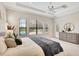 Bright main bedroom features tray ceiling, large windows, and a view of the backyard pool, creating a tranquil retreat at 12710 Stone Ridge Pl, Lakewood Ranch, FL 34202