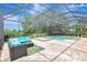 Spacious screened-in patio with a pool, hot tub, and outdoor seating area with lush landscaping at 12710 Stone Ridge Pl, Lakewood Ranch, FL 34202