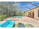 Enclosed patio with large pool, brick flooring, and blue outdoor furniture at 12710 Stone Ridge Pl, Lakewood Ranch, FL 34202