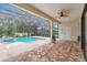 A covered patio with fan overlooks the brick-paved pool and lush backyard at 12710 Stone Ridge Pl, Lakewood Ranch, FL 34202