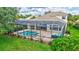 Backyard view featuring a screened-in pool, spa, brick patio, and neat landscaping at 12710 Stone Ridge Pl, Lakewood Ranch, FL 34202