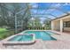Brick paved pool and spa inside screened lanai with greenery backyard views at 12710 Stone Ridge Pl, Lakewood Ranch, FL 34202