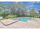 An inviting pool and spa surrounded by brick-paved deck inside screened lanai at 12710 Stone Ridge Pl, Lakewood Ranch, FL 34202