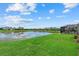 A view from a lush green backyard with a serene pond view, complimented by neighborhood homes at 14216 Florida Rosemary Dr, Bradenton, FL 34211