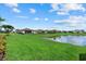 A lush green backyard with a pond view, complimented by additional homes with fenced-in yards at 14216 Florida Rosemary Dr, Bradenton, FL 34211
