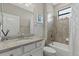 Bathroom with granite countertop, white cabinets, and tiled shower with clear glass door at 14216 Florida Rosemary Dr, Bradenton, FL 34211