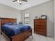 Bedroom features a ceiling fan, a window and a wooden bed with blue bedding and matching wooden dresser at 14216 Florida Rosemary Dr, Bradenton, FL 34211