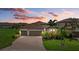 Charming home with a tile roof, a three-car garage, a brick paver driveway, and lush landscaping at 14216 Florida Rosemary Dr, Bradenton, FL 34211