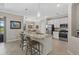 Kitchen features an island with seating, pendant lighting, stainless steel appliances, and white cabinetry at 14216 Florida Rosemary Dr, Bradenton, FL 34211