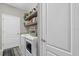 Functional laundry room featuring modern appliances, floating shelves, and ample storage for household needs at 14216 Florida Rosemary Dr, Bradenton, FL 34211