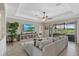Spacious living room with a large sofa, flat screen television, and sliding glass doors to the lanai at 14216 Florida Rosemary Dr, Bradenton, FL 34211