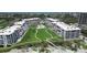 Beautiful aerial view of beachfront condos with a lush green lawn, swimming pool, and scenic surroundings at 1445 Gulf Of Mexico Dr # 203, Longboat Key, FL 34228
