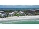 Stunning aerial view of beachfront condos with pristine beach, blue ocean, and well-manicured landscaping at 1445 Gulf Of Mexico Dr # 203, Longboat Key, FL 34228