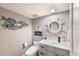 Charming half-bath features vanity sink, toilet, and nautical-themed decor at 1445 Gulf Of Mexico Dr # 203, Longboat Key, FL 34228