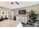 Bright bedroom featuring a white dresser, mounted TV, and stylish decor at 1445 Gulf Of Mexico Dr # 203, Longboat Key, FL 34228