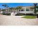 Inviting two-story Players Club with white exterior, red tile roof, palm trees, and a welcoming entrance for a luxurious community atmosphere at 1445 Gulf Of Mexico Dr # 203, Longboat Key, FL 34228