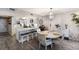 Open-concept dining area featuring wood floors, a kitchen island with seating, and natural light at 1445 Gulf Of Mexico Dr # 203, Longboat Key, FL 34228