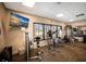 Well-equipped gym featuring modern exercise machines, a wall-mounted TV, a large window, and a mirrored wall at 1445 Gulf Of Mexico Dr # 203, Longboat Key, FL 34228