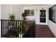 Welcoming condo hallway with tiled floor, decorated with plants, and natural light coming through the windows at 1445 Gulf Of Mexico Dr # 203, Longboat Key, FL 34228