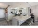 Bright, airy kitchen featuring white cabinets, stainless steel appliances, and a spacious quartz countertop island with seating at 1445 Gulf Of Mexico Dr # 203, Longboat Key, FL 34228