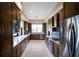 Spacious kitchen with stainless steel appliances, granite countertops, sleek backsplash, wood cabinets, and tile flooring at 1445 Gulf Of Mexico Dr # 203, Longboat Key, FL 34228