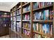Floor-to-ceiling wooden bookshelves filled with a wide variety of literature, complemented by stylish decor and lighting at 1445 Gulf Of Mexico Dr # 203, Longboat Key, FL 34228