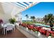Inviting patio with outdoor dining and view of the pool and beach at 1445 Gulf Of Mexico Dr # 203, Longboat Key, FL 34228